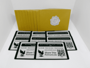 Set of 10 Share This Forward Kindness Notes paired with golden envelopes sealed by silver heart stickers, each note carrying an uplifting message to inspire and spread kindness forward